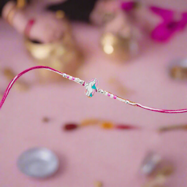 pink rakhi featuring a charming unicorn design.