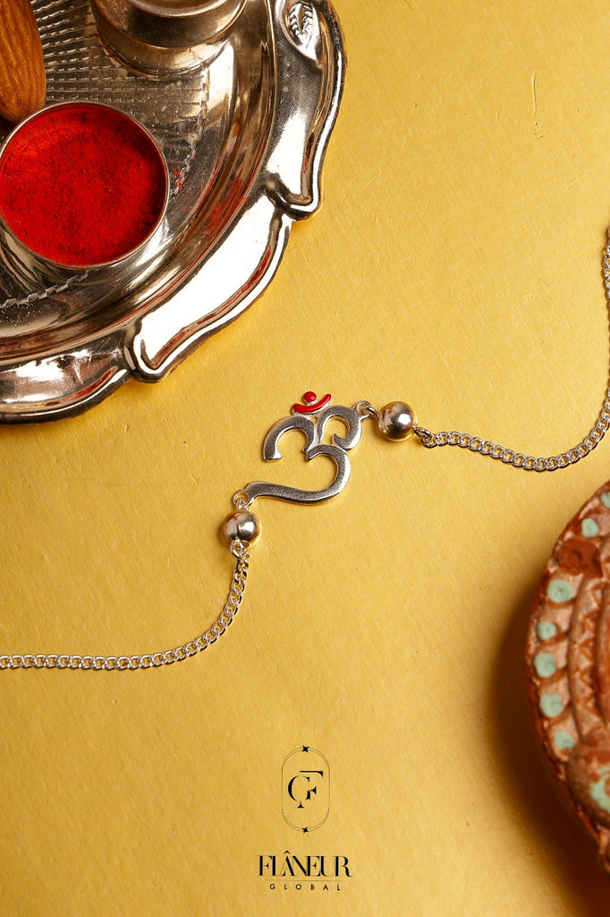 silver rakhi combines the sacred symbol of Om with a genuine rudraksh
