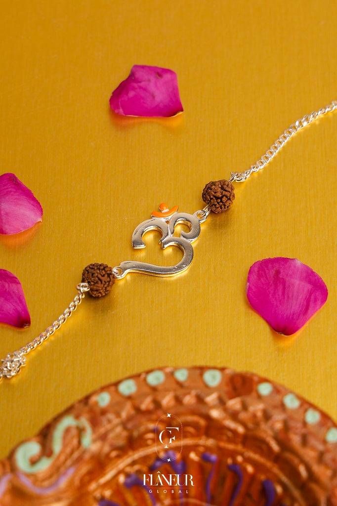 silver rakhi combines the sacred symbol of Om with a genuine rudraksh