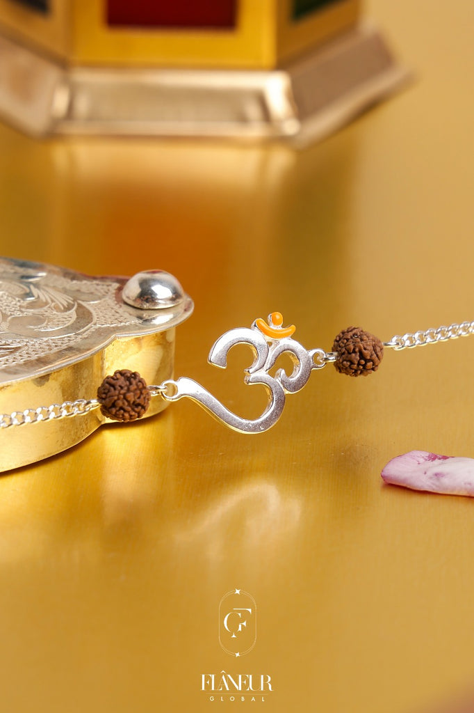 silver rakhi combines the sacred symbol of Om with a genuine rudraksh